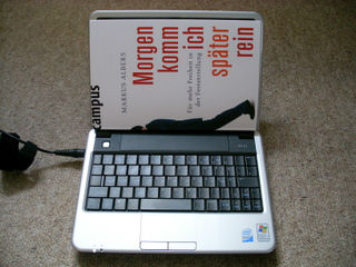 Dell Inspiron Mini 910 mit einem Buch als Vergleich